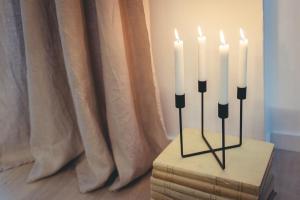 un candelabro con tre candele bianche su una scatola di BR Treviso Train Station Apartments a Treviso