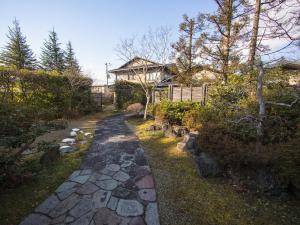 un camino de piedra frente a una casa en 富谷緑水庵茶道体験 en Nanakita