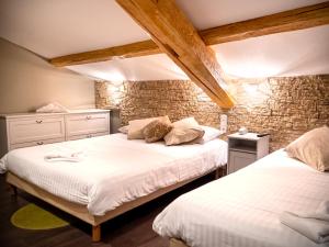 una camera da letto con due letti e un muro di mattoni di Altera Roma Hôtel ad Avignone
