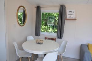 a white table and chairs in a room with a window at Chalet de Parel in Petten