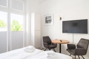 - une chambre avec un lit, deux chaises et une table dans l'établissement JOHOUSE Apartment 02, à Warnemünde