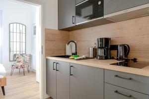 uma cozinha com armários brancos e uma bancada em JOHOUSE Apartment 7 em Warnemünde