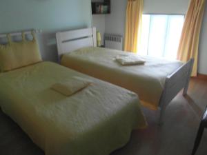 1 dormitorio con 2 camas y ventana en GITE A LA FERME en Le Pin-Saint-Denis