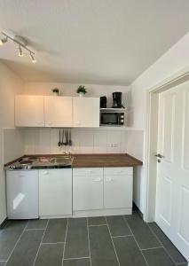 a kitchen with white cabinets and a counter top at Bernsteinsucher in Norden