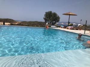 a man is swimming in a swimming pool at Acti Plaka Hotel in Plaka