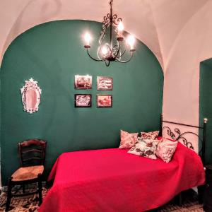a bedroom with a red bed with a green wall at Casa Rural Maribel in Santa Amalia