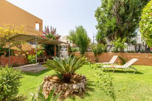a garden with a palm tree in the yard at Anna's Sea House near to a sandy beach! in Kato Daratso