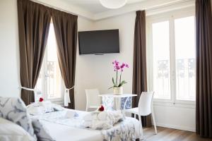 een slaapkamer met een tafel en een tv aan de muur bij Albergo La Rocca in Brisighella