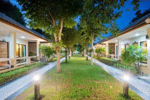 a courtyard of a house with trees and lights at Tontan Resort Cha-am in Cha Am Beach