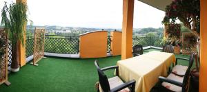 a balcony with a table and chairs on a green floor at Villa Historia in Biecz