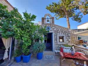 une maison en pierre avec une cour ornée de plantes dans l'établissement 1882 Hotel, à Alaçatı