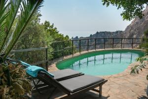 a bridge over a swimming pool with a chaise at B&B Muse Marbella in Marbella