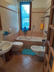 een badkamer met 2 wastafels, een toilet en een bad bij CASA VACANZE DA NONNA MELA in Alghero
