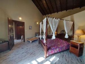 a bedroom with a canopy bed and a wooden floor at 1882 Hotel in Alaçatı