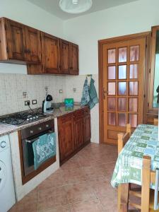 een keuken met een fornuis top oven naast een tafel bij CASA VACANZE DA NONNA MELA in Alghero