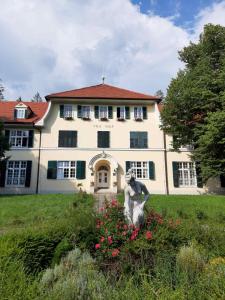 a large white house with a statue in front of it at VILLA GOLF Crystal Drop Apartment in Rogaška Slatina