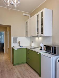 a kitchen with green and white cabinets and appliances at Cosy one seperate bedroom apartment in city center, perfect for family trip. in Rīga