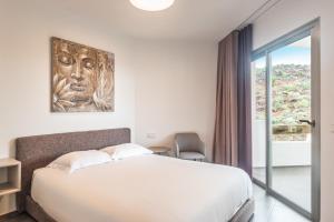 a bedroom with a large bed and a window at Gazmira 21 DELUXE 2B in Palm-mar +9 photos