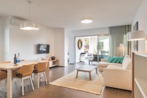 a living room with a couch and a dining room at Gazmira 21 DELUXE 2B in Palm-mar