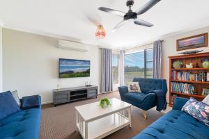 uma sala de estar com dois sofás azuis e uma televisão em Seabreeze Haven -Wifi, Netflix, pet friendly beach house em Cowes