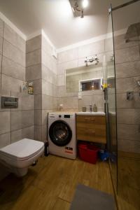 a bathroom with a washing machine and a toilet at Wyspa Uznam Sun Tower in Świnoujście