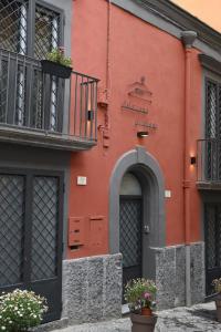 un edificio rosso con balcone e porta di B&B Palazzina Avallone a Napoli