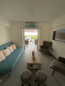 een woonkamer met een blauwe bank en een tafel bij Casa Azzuro - Luxurious Modern Apartment Kapparis in Paralimni