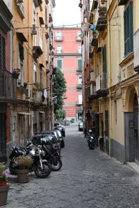 un gruppo di motocicli parcheggiato in una strada tra edifici di B&B Palazzina Avallone a Napoli