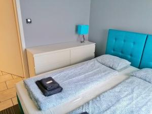 a bedroom with a bed with a blue head board at 3K - Island in Świnoujście