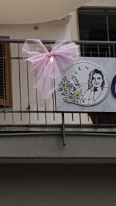 a sign on a balcony with a pink bow at B&B Carol in Cetara