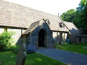 uma velha igreja de pedra com uma grande porta em The Old Barn em Buxton