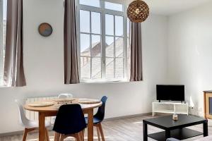 a living room with a table and chairs and a tv at AMX3 - L'horizon des vues de l'espace et du bien être in Ault