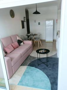 a living room with a pink couch and a table at S. Soares Riviera Flat in Portimão