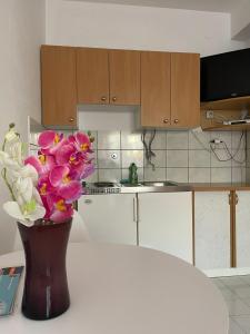 a vase of flowers sitting on a table in a kitchen at apartmani Mirko Storić in Vodice