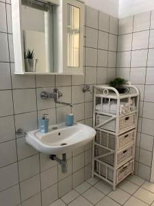 a bathroom with a sink and a mirror and baskets at apartmani Mirko Storić in Vodice