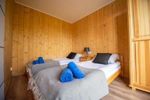 two beds in a room with wooden walls at Siedlisko 14 Chata in Mikołajki