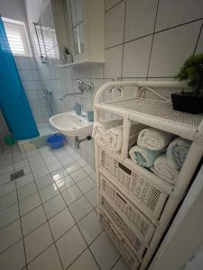 a bathroom with a rack of towels and a sink at apartmani Mirko Storić in Vodice
