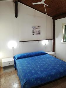 a bedroom with a blue bed and two night stands at CAMPING MADDALENA in Palinuro