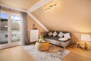 a living room with a couch and a large window at Ferien-Apartment Seewiesen - mit priv Strandzugang in Friedrichshafen