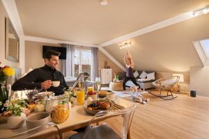 a man sitting at a table with food on it at Ferien-Apartment Seewiesen - mit priv Strandzugang in Friedrichshafen