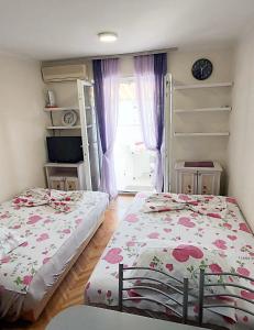 Un dormitorio con dos camas y una ventana. en Sunčani apartman 1-Vila Amfora, en Budva