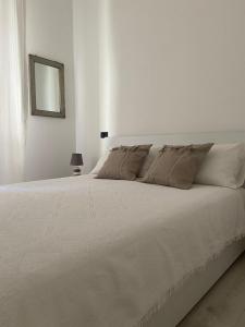 a white bed in a white bedroom with a mirror at CASA TERESA in Lido Adriano