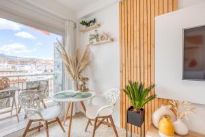 ein Esszimmer mit einem Tisch und Stühlen sowie einem Balkon in der Unterkunft Hanami Avenida de España Beach Front - Mountain View in Estepona