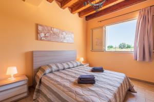 Schlafzimmer mit einem Bett und einem Fenster in der Unterkunft Casa Vacanza Brucoli Mare 2 in Brucoli