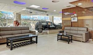 a lobby with two couches and a car in a window at Itsy By Treebo - BCP Suites in Bangalore
