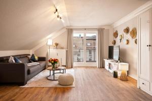 a living room with a couch and a tv at Ferien-Apartment Riedperle mit Privatstrandzugang in Friedrichshafen