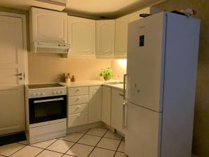 uma cozinha com armários brancos e um frigorífico branco em Sentrumsnær leilighet med 3 soverom. em Bergen