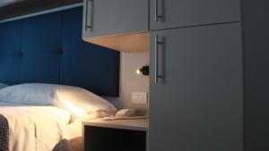 une chambre avec un lit avec une tête de lit bleue et un téléphone dans l'établissement Hotel Danieli, à Lido di Jesolo