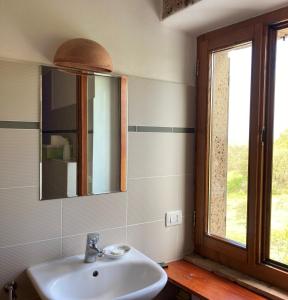 baño con lavabo, espejo y ventana en Casale Mavianda, en San Lorenzo Nuovo
