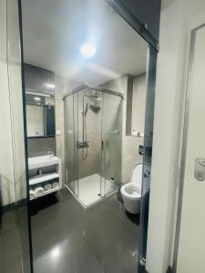 a bathroom with a glass shower and a toilet at Ergosuites in Figueira da Foz